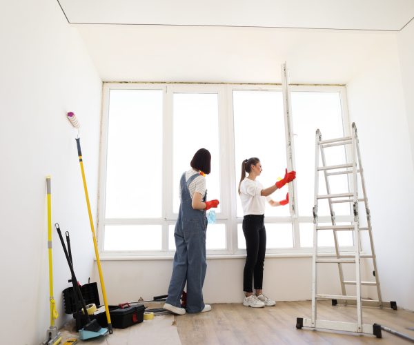 Attractive caucasian girls making house cleaning after repair.
